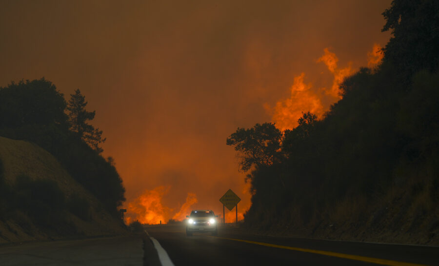 The Line Fire jumps highway 330 as a motorist speeds past Saturday, Sept. 7, 2024, near Running Springs, Calif. (AP Photo/Eric Thayer) (Foto: Eric Thayer)