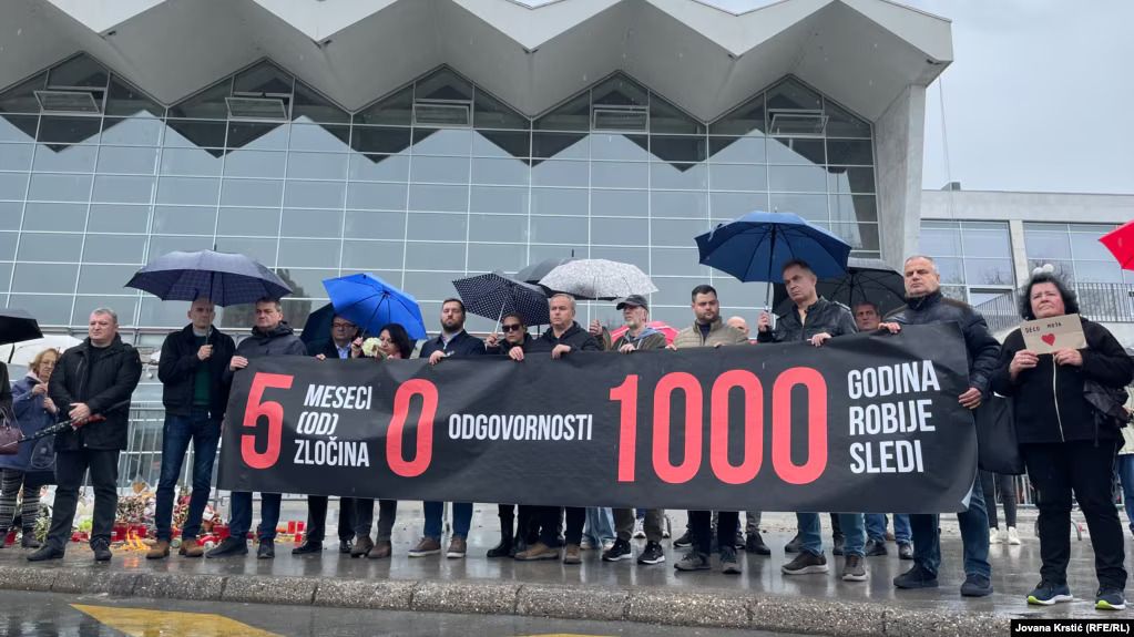Transparent sa natpisom "5 mjeseci (od) zločina, 0 odgovornosti, 1000 godina robije slijedi" ispred Željezničke stanice u Novom Sadu, 1. aprila 2025. (Foto: Jovana Krstić (RFE/RL))