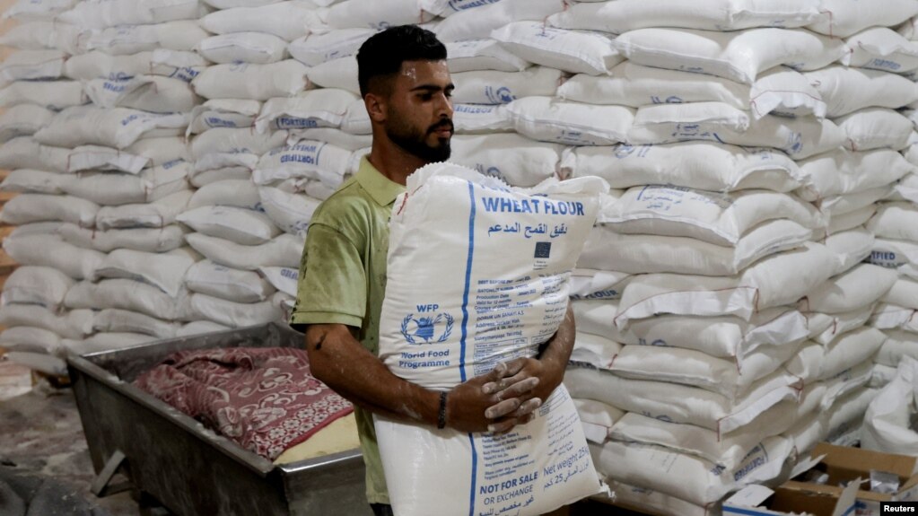 Palestinski radnik nosi vreću brašna Svjetskog programa za hranu u Pojasu Gaze, 22. maj 2025. (Foto: Reuters)