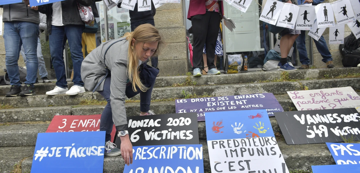 Ljudi postavljaju plakate tokom demonstracija uoči izricanja presude na suđenju Žoelu Le Skuarnjeku, 74-godišnjem bivšem hirurgu optuženom za silovanje i seksualno zlostavljanje 299 djece, u srijedu, 28. maja 2025. godine u Vanu, Bretanja, zapadna Francuska (Foto: AP/Matje Patje)