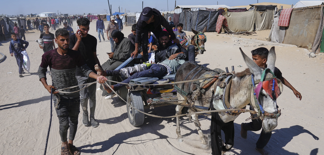 Palestinci nose ranjenog muškarca nakon što je pogođen na punktu za podjelu humanitarne pomoći u Kan Junisu, na jugu Pojasa Gaze, u četvrtak, 29. maja 2025. (Foto: AP Photo/Abdel Kareem Hana)