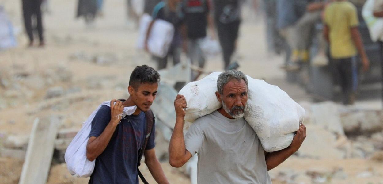 Palestinci nose pomoć koju pruža GHF. (Foto: Reuters)