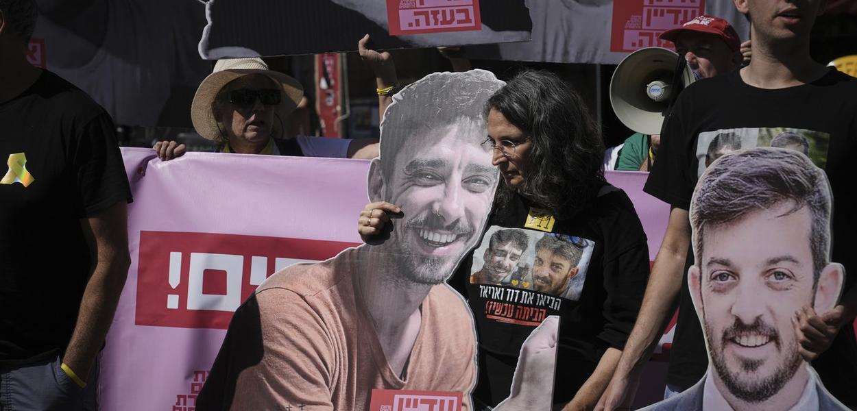 Demonstranti drže fotografije sa likovima izraelskih talaca koji se drže u Pojasu Gaze, tokom protesta na kojem se zahteva njihovo oslobađanje iz zarobljeništva kod Hamasa i protivi izraelskoj ofanzivi u gradu Gazi, u Jerusalimu (Foto: AP/Mahmoud Illean)