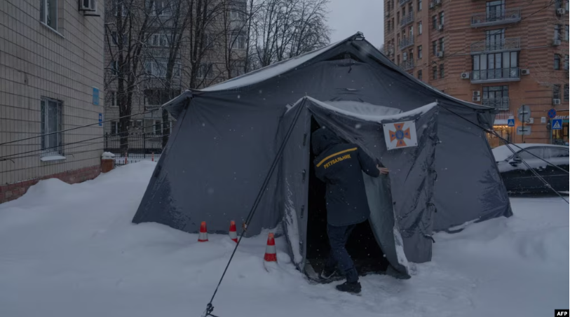 Pripadnik spasilačkih ekipa u Kijevu otvara šator na takozvanoj tački nesalomivosti, gdje ljudi mogu da pune mobilne uređaje i da se griju usred surovih zimskih uslova u gradu, 9. januar 2026. (Foto: AFP)