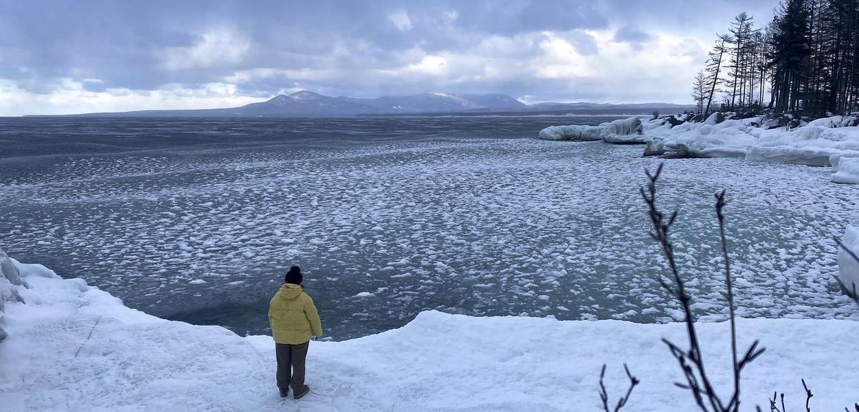 Turista stoji nadomak jezera Bajkal u Rusiji, 1. januar 2025. (Foto: AP Photo)