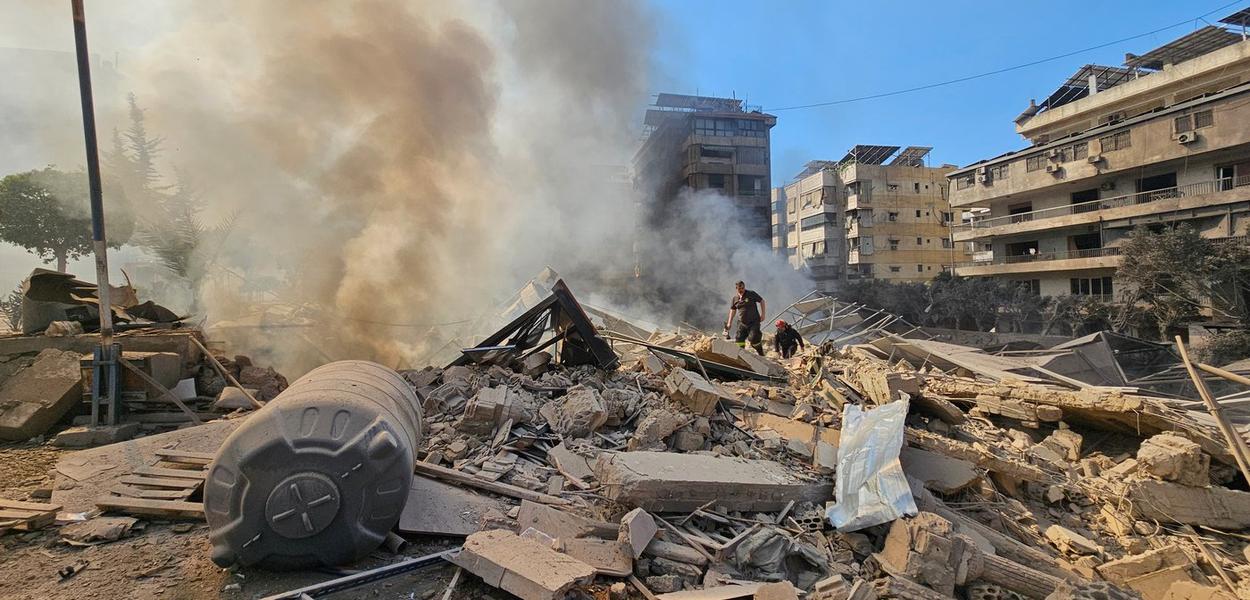 Vatrogasci pregledaju ruševine dok dim izlazi iz zgrade pogođene izraelskim vazdušnim napadom u Dahiyehu, južnom predgrađu Bejruta, Liban, utorak, 3. mart 2026.  (Foto: AP photo/Hassan Ammar)