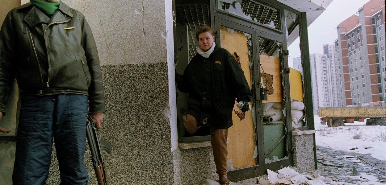 Stanovnici Bosne izbjegavaju snajpersku vatru ulazeći u svoju stambenu zgradu kroz razbijeni prozor, blizu srpskih linija fronta u Sarajevu, Bosna i Hercegovina, 26. februara 1993. (Foto: AP Photo/Peter Northall)