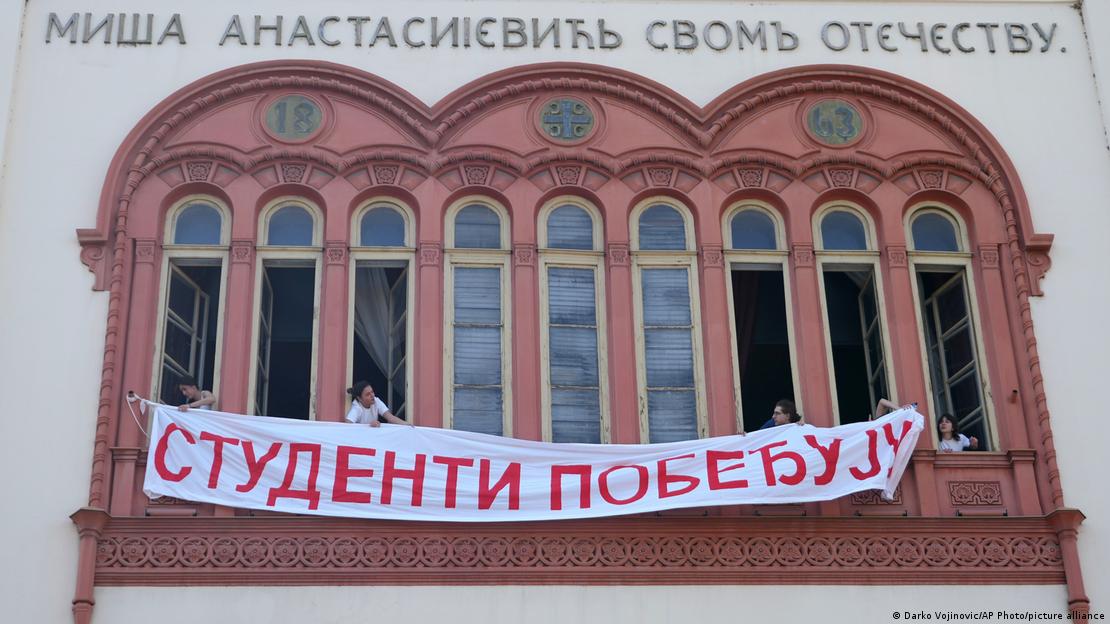 Studenti razvijaju baner sa natpisom "Studenti pobeđuju" na zgradi Rektorata