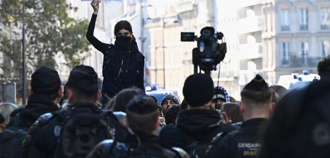 A women raises a placard during protests over living costs and education in Paris, France, Saturday, Oct. 31, 2026. (AP Photo/Emma Da Silva) (Foto: AP)